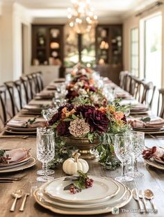 a long table set with plates, silverware and pumpkins for an elegant thanksgiving dinner