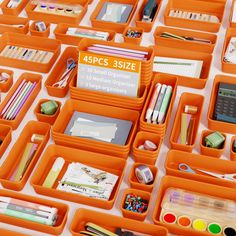 an assortment of office supplies are displayed on a white table top with orange trays