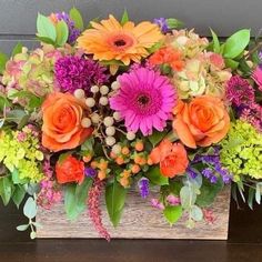 a wooden box filled with lots of colorful flowers