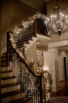 a staircase decorated for christmas with lights and garland on the bannister railings