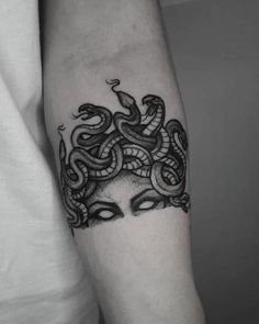 a woman's arm with a snake tattoo on it