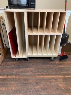 a television is sitting on top of a shelf with shelves and brooms in front of it