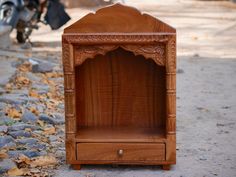 a wooden shelf sitting on the ground next to a motorcycle