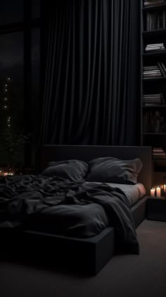 a bed with black sheets and pillows in a dark room next to a bookshelf