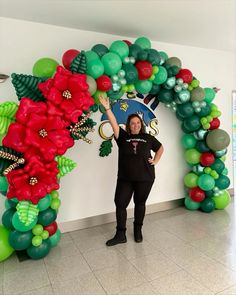 a woman standing in front of a balloon arch