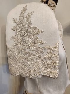 the back of a woman's white dress with an embroidered design on it