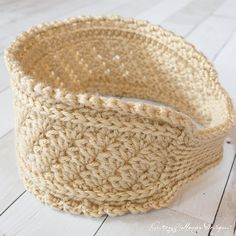 a crocheted basket sitting on top of a white wooden floor