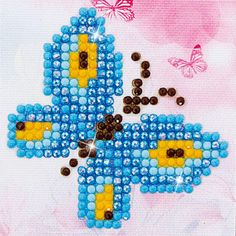 the cross is made out of beads and has butterflies flying around it on a pink background