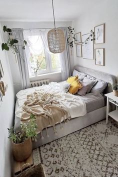 a bedroom with a bed, plants and pictures on the wall