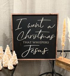 a sign that says i want a christmas that whispers jesus next to some small trees