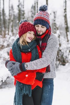 a man and woman hugging in the snow