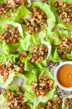 lettuce cups filled with chicken and sauce on a plate next to dipping sauce