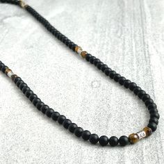 Men's beaded necklace features: ~ 6mm Matte Onyx beads ~ 6mm Faceted Yellow Tiger Eye beads ~ 6mm Sterling Silver tube beads ~ Choose your length; 20", 22", 24", 26", 28", 30" ~ Clasp-free, made with clear stretchy cord to easily put on and take off ~ Comes packaged in a re-usable microfiber pouch ~ Use the sizing guide found in the photo gallery to choose the length that's right for you Inner Glow, Sterling Necklaces, Tiger Eye Beads, Eye Beads, Onyx Bead, Tube Beads, Tiger Eye, Necklaces Bracelets, Photo Gallery