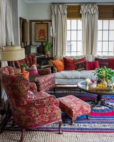 a living room filled with lots of furniture and decor on top of a carpeted floor