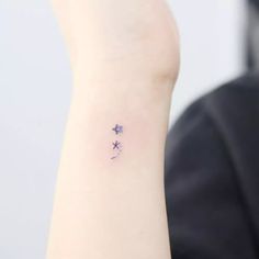 a small star tattoo on the left wrist is shown in blue ink, and it appears to be tiny