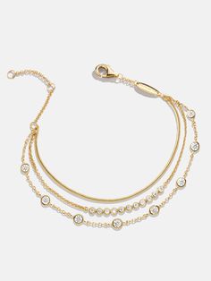 Instantly elevate your wrist stack with the Selene 18K Gold Layered Bracelet — a twist on our best-selling Skye Bracelet. Its three individual chain layers go on easily with a single clasp. Crafted from 18K gold plated sterling silver and accented with cubic zirconia stones, this bracelet is the chicest everyday essential for effortless style. Gold Layered Bracelets, Black Beads Mangalsutra Design, Modern Gold Jewelry, Layered Bracelet, Diamond Jewelry Designs, Chic Earrings, Gold Bangles Design, Gold Fashion Necklace