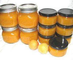 several jars filled with orange colored liquid next to some lemons