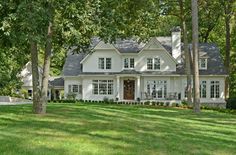 a large white house surrounded by trees and grass