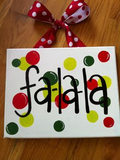 a painted sign with polka dots and the word falaf on it, tied to a wooden floor