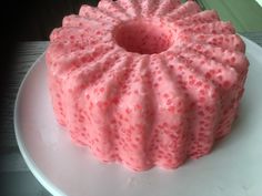 a pink cake sitting on top of a white plate