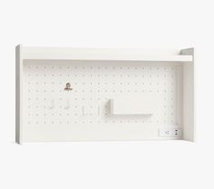 a white wall mounted shelf with pegs and two toothbrushes on the side