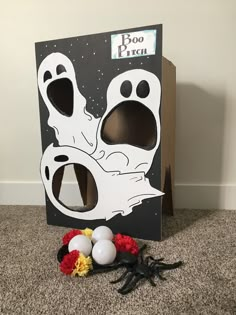 a cardboard box with two ghost faces on it and some decorations in front of it