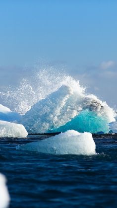 an iceberg in the ocean with some water splashing on it's side