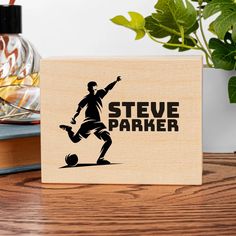 a wooden block that says steve parker with a soccer player kicking a ball on it