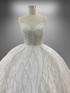 a white ball gown with silver sequins on it