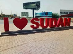 the word i love sudan is displayed in front of a large sign that says i love sudan