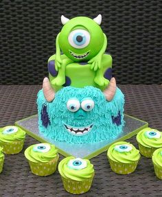 there is a monster cake and cupcakes on the table with green frosting