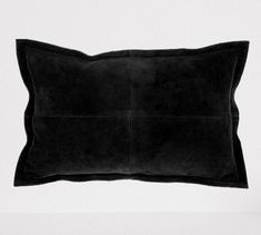 a black pillow sitting on top of a white table