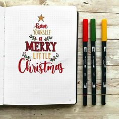 an open notebook with christmas lettering and crayons