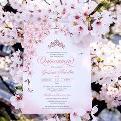 an ornate wedding card with pink flowers on the front and bottom, surrounded by cherry blossoms