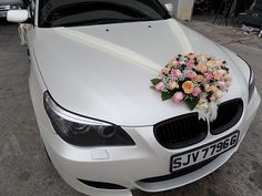 a white car with flowers on the hood