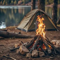 a campfire is lit in front of a tent on the ground next to some logs