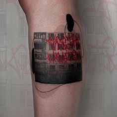 a person with a black and red tattoo on their leg