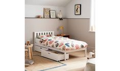 a white bed with drawers underneath it in a bedroom next to a table and chair