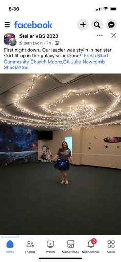 a woman standing in a room with lights on the ceiling and an instagram page below