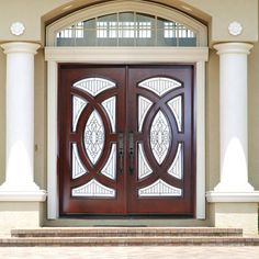 the front door to a house with two glass doors on each side and columns around it