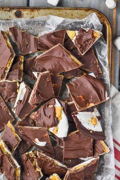 a tray filled with pieces of chocolate and marshmallows