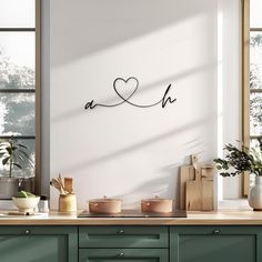 a kitchen with green cabinets and white walls, has a heart shaped sign on the wall