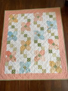 a quilt is laying on the floor in front of a wooden floor and wood floors