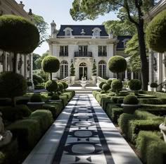 a large white house surrounded by hedges and trees