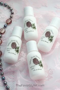 three bottles of body lotion sitting on top of a lace covered table