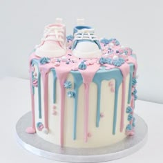 a cake decorated with pink, blue and white icing on top of a table