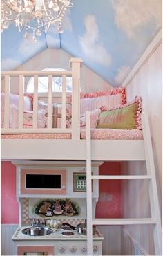 a white bunk bed sitting under a chandelier next to a sink and stove