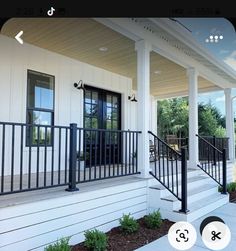 the front porch of a house with black railings