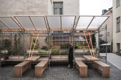 a person standing in front of a building with lots of plants