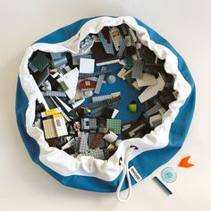 a bag filled with legos on top of a blue and white cloth covered table